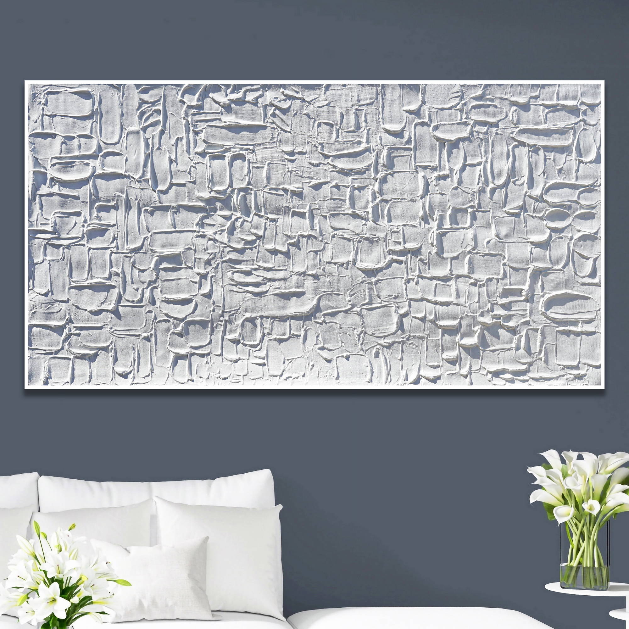 Quadro astratto bianco con texture tridimensionale appeso a parete grigia