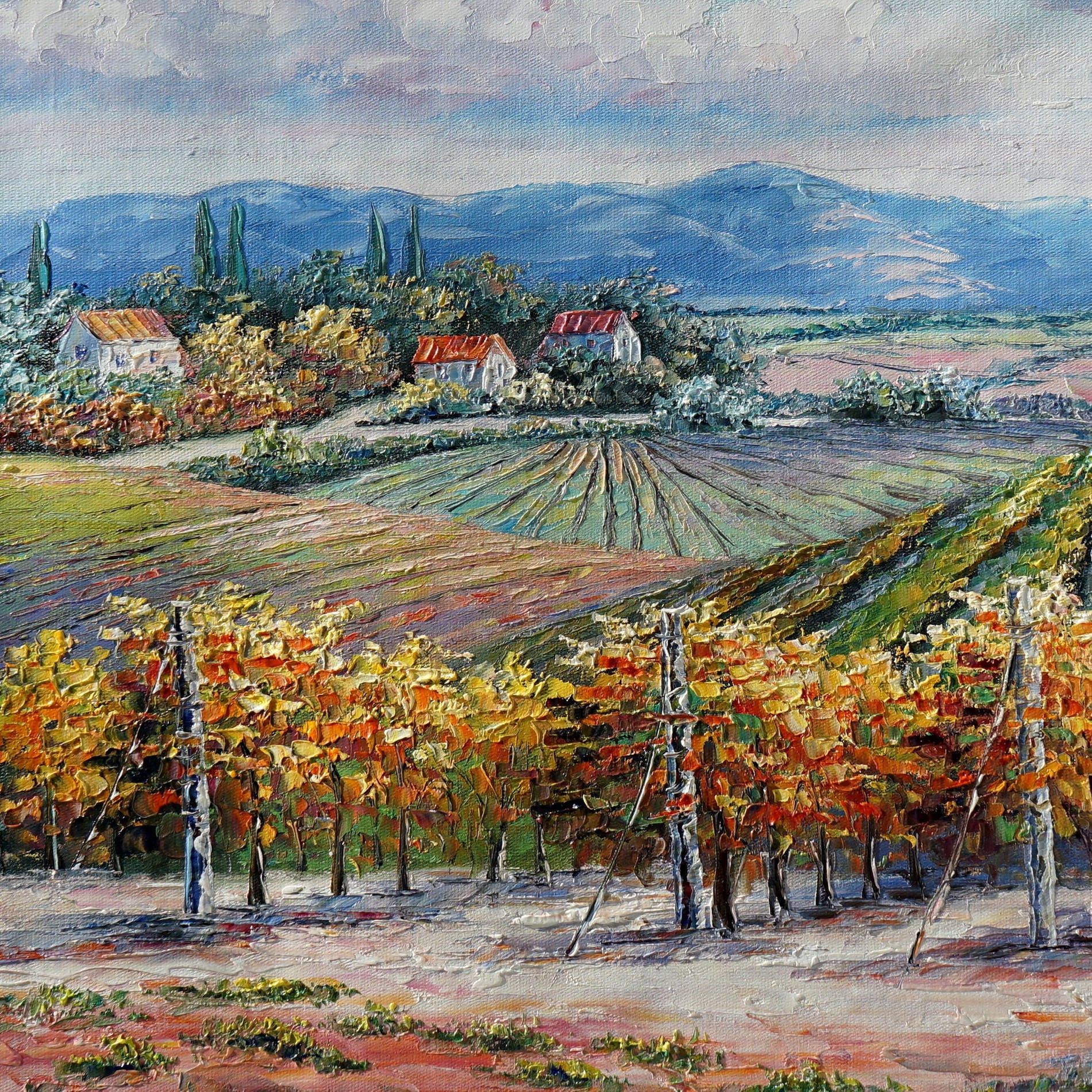 Dipinto di vigne autunnali con colline e cielo nuvoloso